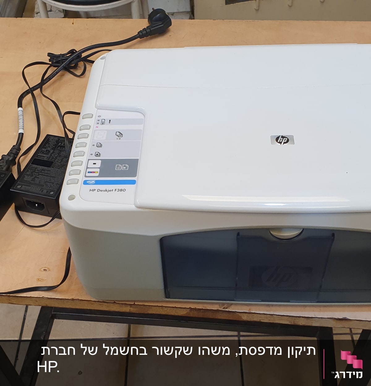 מדפסת HP Deskjet F380 על שולחן עם כבלים